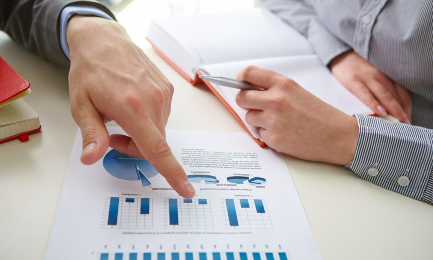 Professional working on financial analysis with laptop and documents